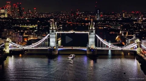 Beleuchtete Themse-Brücke bei Nacht während der beleuchteten Bootsfahrt in London