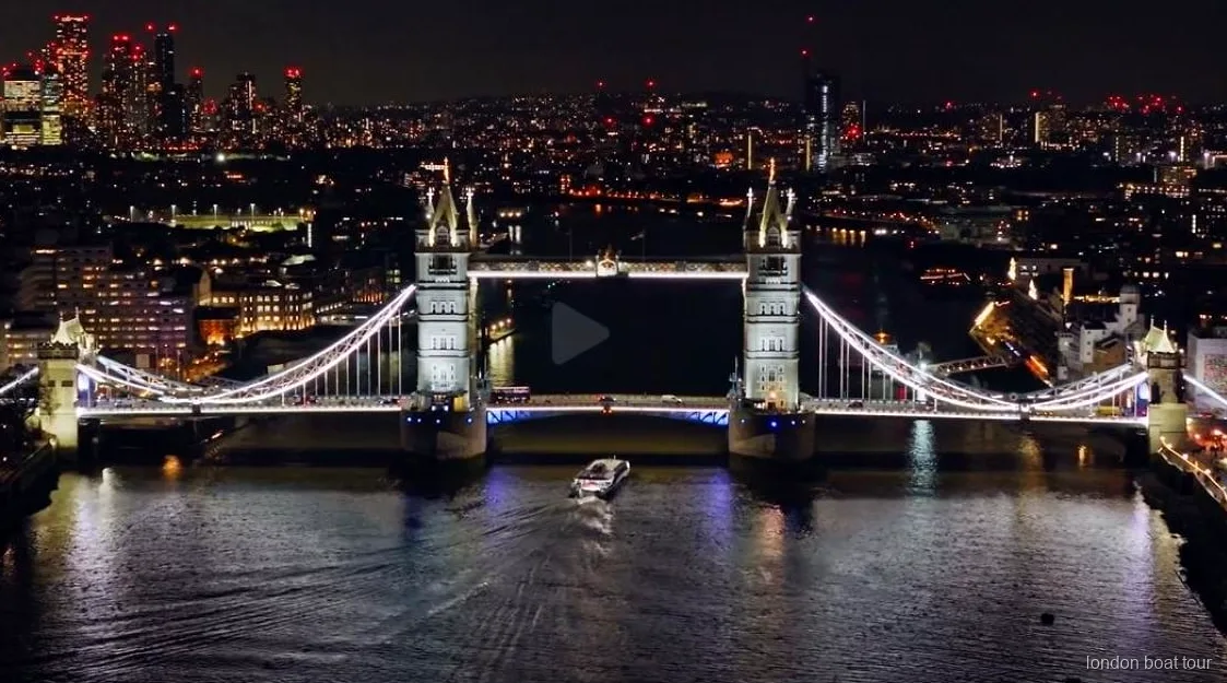 Beleuchtete Themse-Brücke bei Nacht während der beleuchteten Bootsfahrt in London