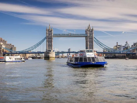 Barca da crociera hop-on hop-off che attracca a un molo di Londra sul Tamigi