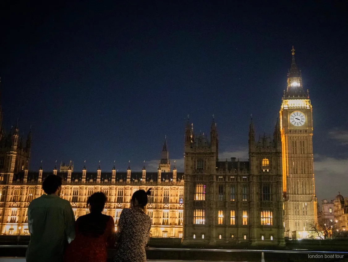 Perfil de Canary Wharf iluminado de noche visto desde un crucero con cena por el Támesis