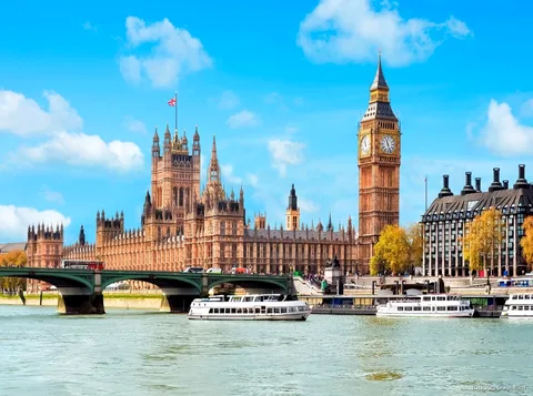 Pasajeros en la cubierta exterior de un crucero por el Támesis con el perfil de Londres detrás