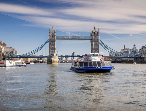 Barco do cruzeiro hop-on hop-off a atracar num cais de Londres
