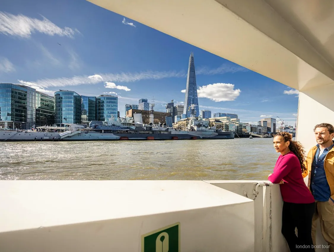 Lugares no deque aberto de um cruzeiro turístico hop-on hop-off com monumentos de Londres ao fundo