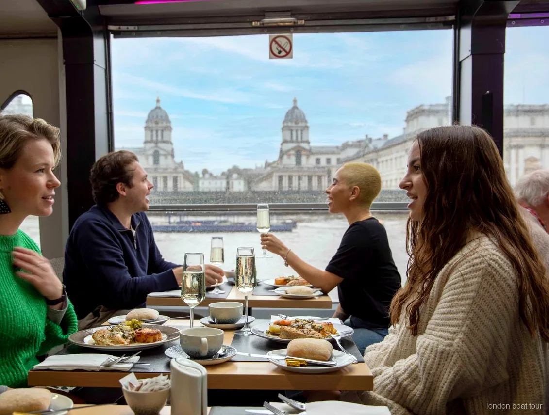 Convives déjeunant à une table près de la fenêtre sur une croisière déjeuner de la Tamise