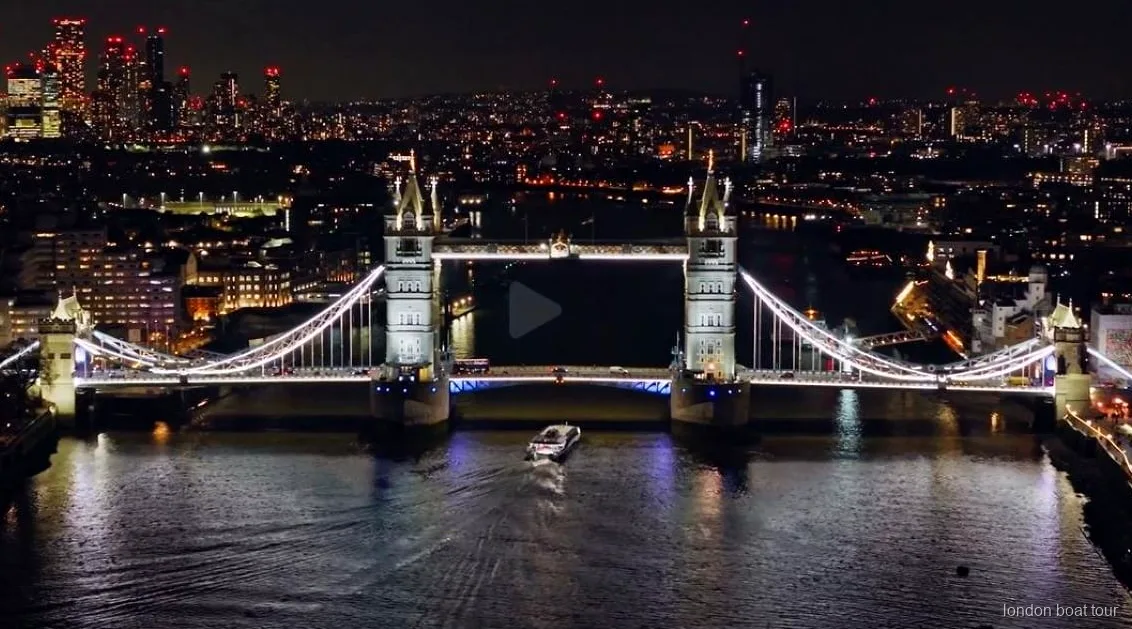 Themsenbro oplyst om natten under den oplyste flodsejltur i London