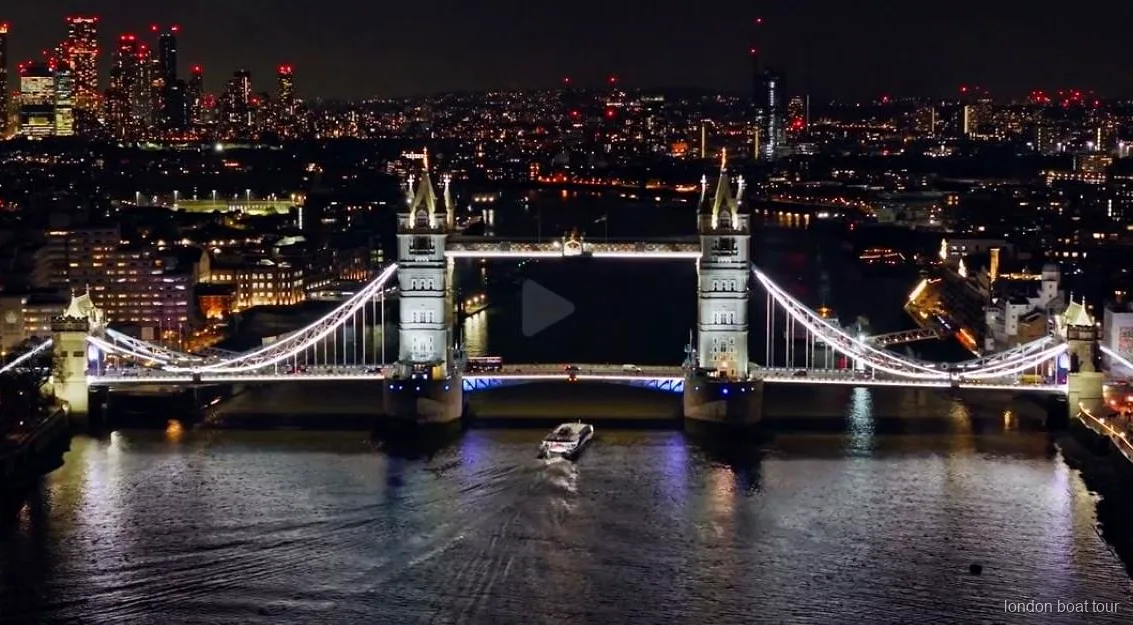Bro på Themsen upplyst nattetid under den upplysta flodkryssningen i London