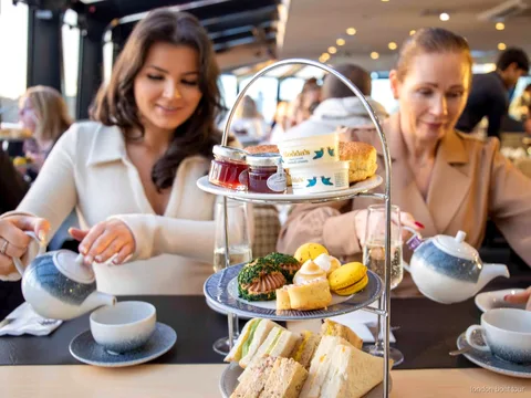 Bir Thames tekne turunda servis edilen sandviçli ve scone'lu afternoon tea tabağı