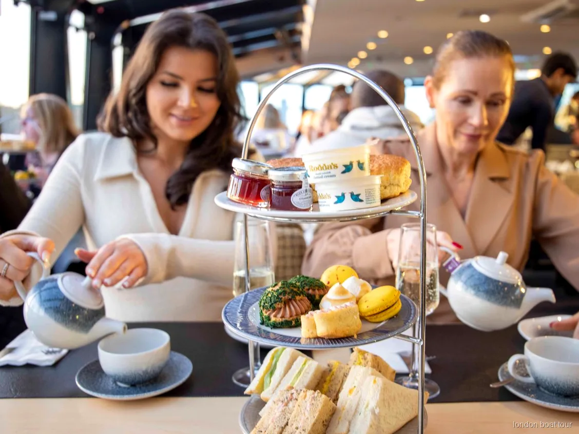 Bir Thames tekne turunda servis edilen sandviçli ve scone'lu afternoon tea tabağı
