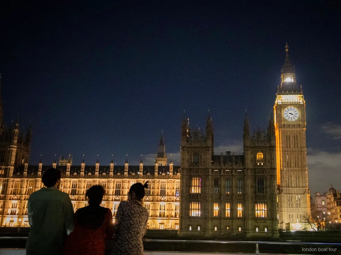 Canary Wharf skyline lit up at night seen from a Thames dinner cruise