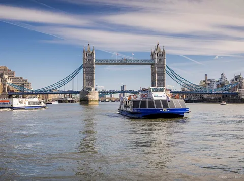 Thames hop-on hop-off cruise boat docking at a London pier