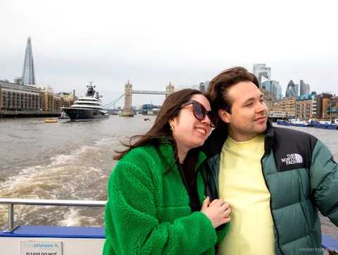 Passengers boarding a hop-on hop-off river cruise boat at a London pier on the Thames