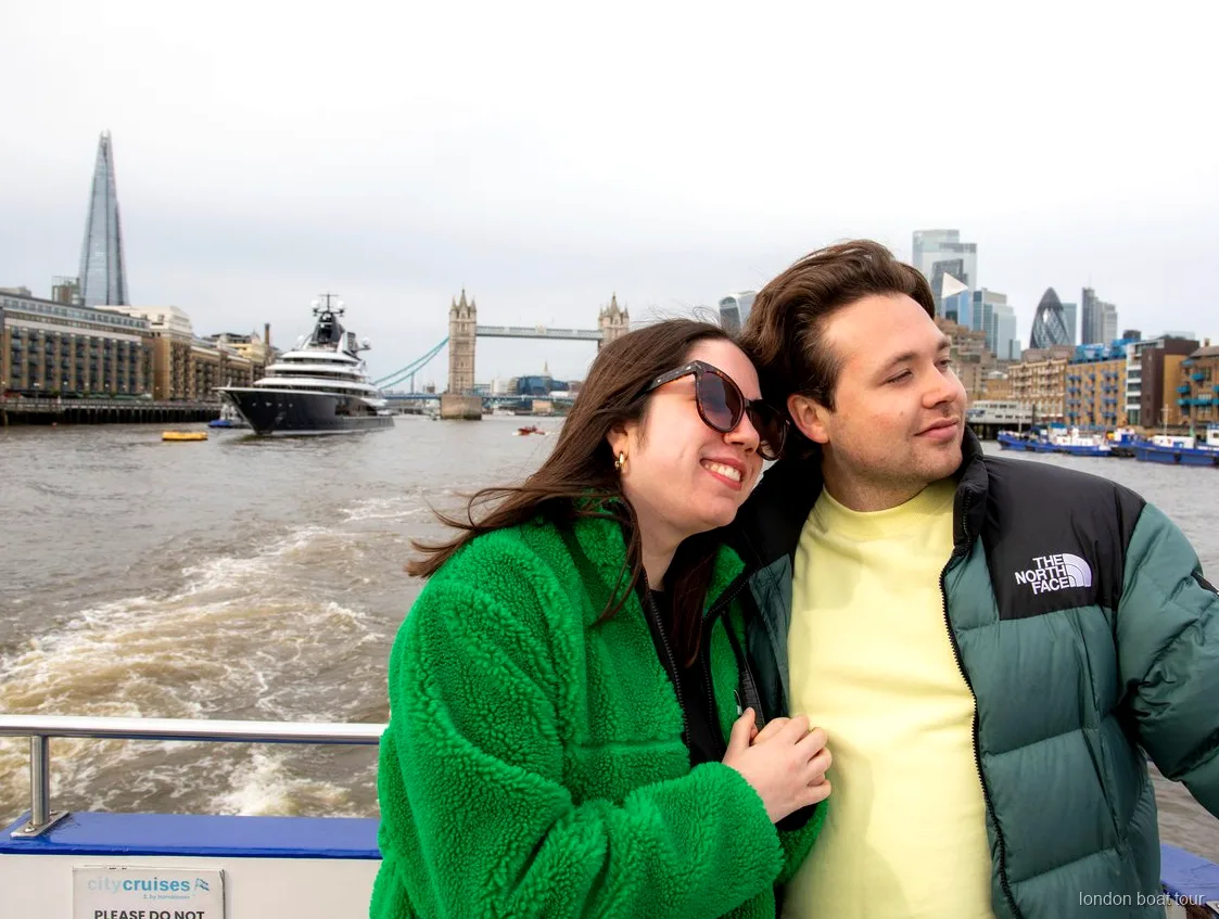 Passengers boarding a hop-on hop-off river cruise boat at a London pier on the Thames