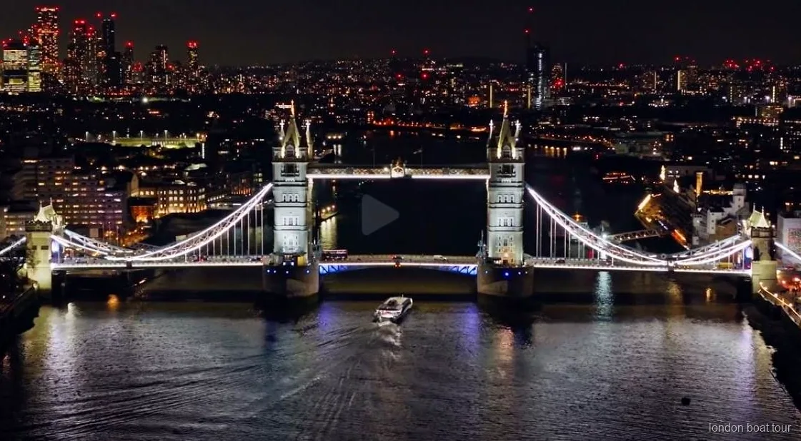 Thames bridge lit up at night during the illuminated river cruise in London