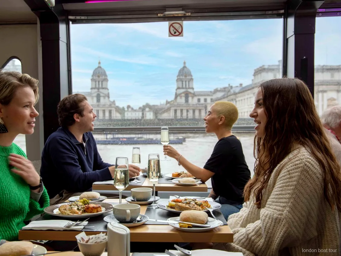 Guests dining at a window table on a Thames river lunch cruise