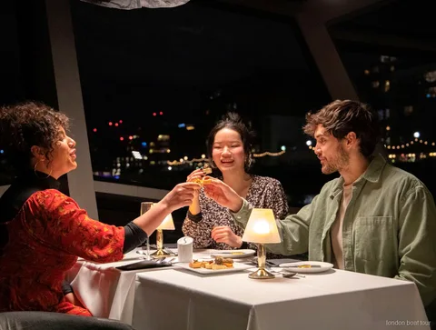 Gedeckter Tisch für ein 3-Gänge-Menü auf einer Themse Dinner Cruise bei Nacht