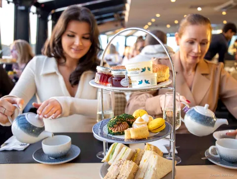 Afternoon tea fad med sandwich og scones serveret på en sejltur på Themsen