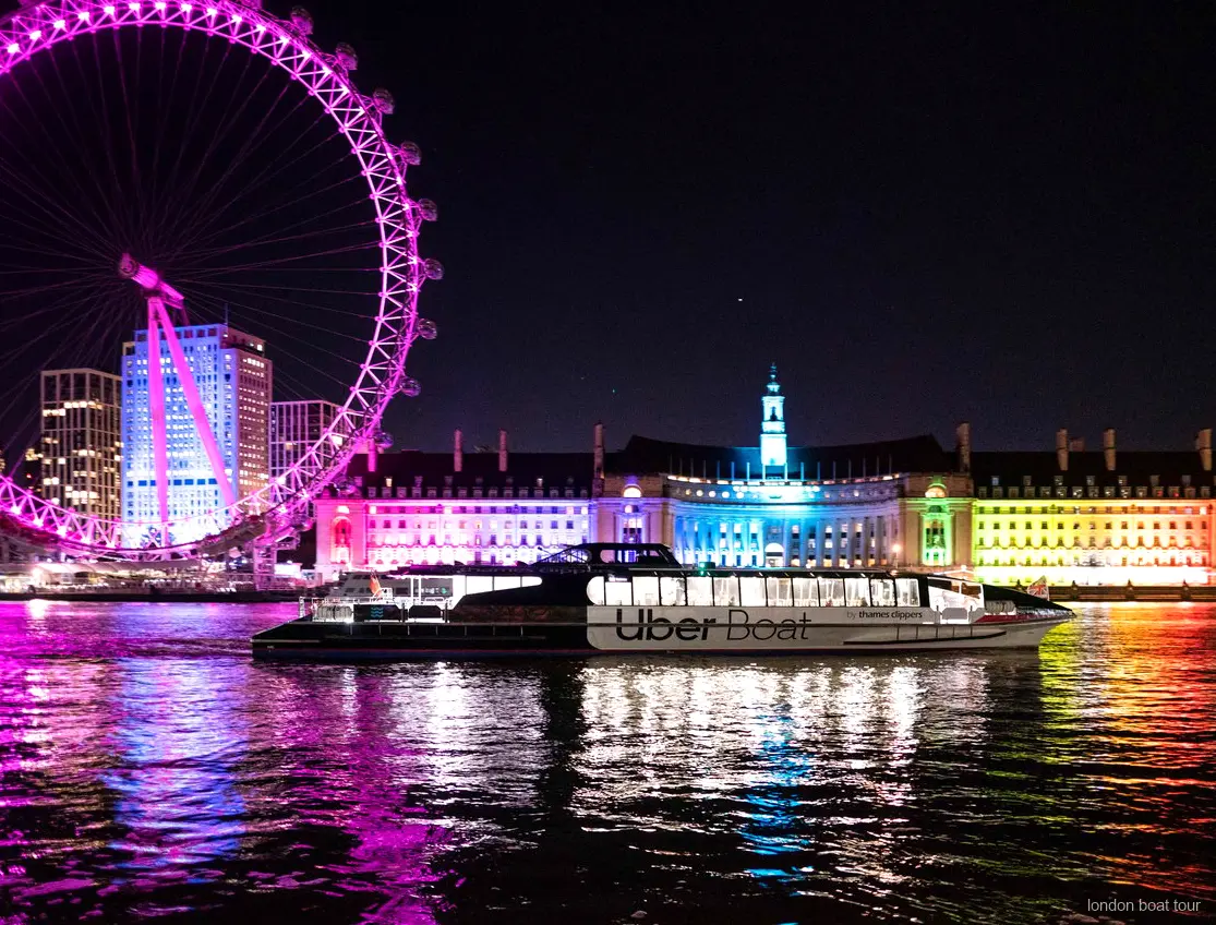 Skyline van Londen verlicht in het donker vanaf de verlichte Theems boottocht